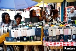 Women vendors display Nokia phone models for sale along with smartphones in Ikeja district in Nigeria's commercial capital Lagos, May 31, 2017.
