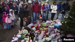 Warga mengunjungi tempat penghormatan untuk para korban pembunuhan massal di Newtown, Connecticut (16/12). (Reuters/L. Jackson)