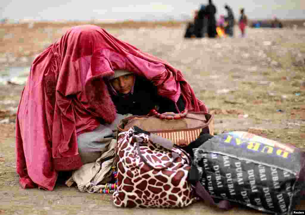 A displaced Iraqi woman covers her daughter during cold weather after fleeing the battle between Iraqi forces and Islamic State militants near Mosul.