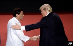 Predsednik Filipina, Rodrigo Duterte, levo, rukuje se sa predsednikom SAD Donaldom Trampom tokom ASEAN samita u Manili, Filipini, 13. novembra 2017.