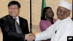 Nigeria National Petrolium Company official Malam Shehu Ladan, right, shakes hands with China State Construction Engineering Corporation official, Yu Zhende following the signing of a Memorandum of Understanding (MOU) in Abuja (File Photo - 13 May 2010)