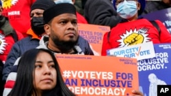 Activists rally on the steps of New York's City Hall ahead of a vote to allow lawful permanent residents to cast votes in elections to pick the mayor, City Council members and other municipal officeholders, Dec. 9, 2021, in New York. 