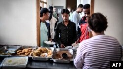 Des migrants font la queue pour déjeuner dans un centre hospitalier d'urgence pour migrants (CHUM) dans un ancien monastère à Bonnelles, Le 28 août 2018.