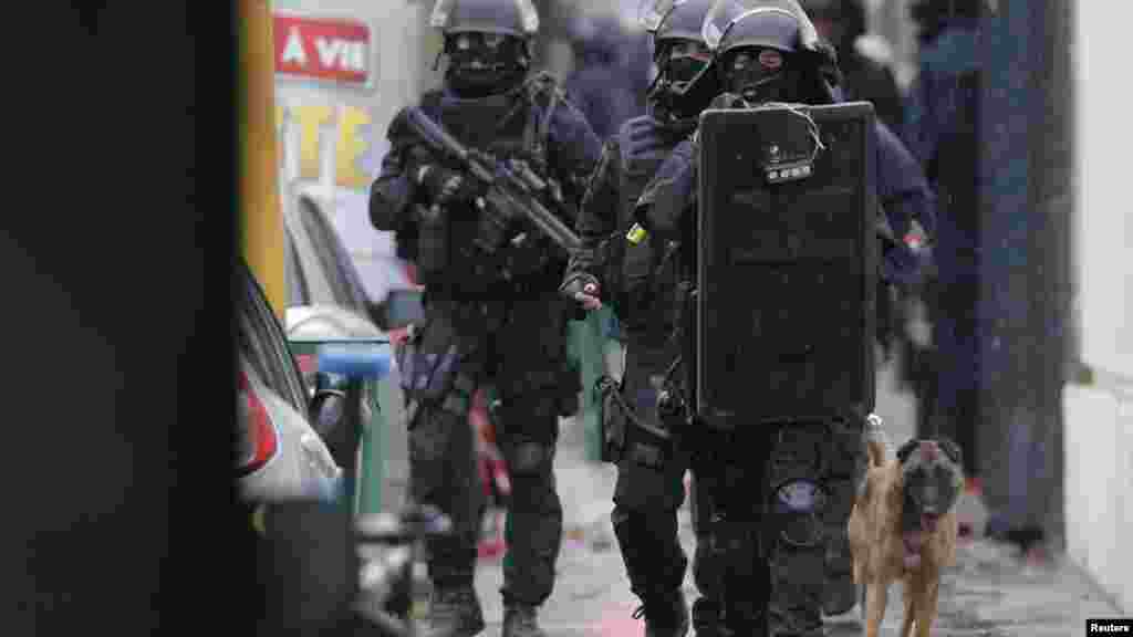 La police d&#39;intervention del&#39;armée française patrouille&nbsp;avec un chien renifleur sur les lieux d&#39;une fusillade dans la rue de Montrouge, près de Paris, le 8 janvier 2015.