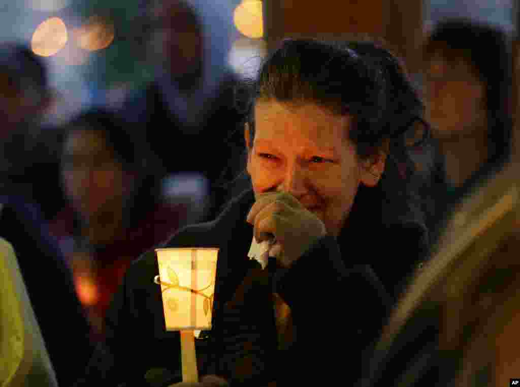 Teresa Welter cries as she holds a candle at a vigil for mudslide victims in Arlington, Washington, March 25, 2014.