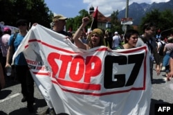 Anti-Group of Seven protesters holds up a banner reading 'Stop G7' in Garmisch-Partenkirchen, southern Germany, June 6, 2015, ahead of the G-7 summit, which Germany will host at Elmau Castle June 7-8.