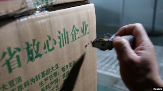 2018年7月4日,在中国山东省曲阜市,在粮油工业和进出口公司的工厂,瓶装大豆油的盒子上印着“放心油企业”“原料产国:美国”。