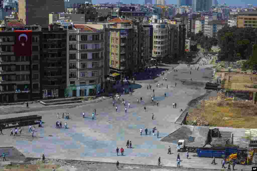 Warga berjalan di dekat Taman Gezi, tak jauh dari Alun-Alun Taksim, Istanbul (17/6). Sehari sebelumnya, polisi anti huru-hara membangun barikado dan menembakkan gas air mata serta meriam air untuk mencegah demonstran kembali ke Taksim.