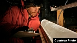 Climate scientist studies ice core from Antarctica. (T. Bauska)