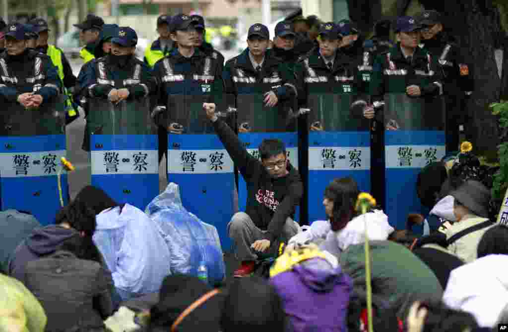 Students protesting against a China Taiwan trade pact rally in front of a wall of police outside of the occupied legislature, in Taipei, Taiwan, March 20, 2014. 