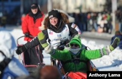 Iditarod rookie Laura Neese of McMillan, Mich., greets the crowd as she mushes through downtown during the ceremonial start of the Iditarod Trail Sled Dog Race in Anchorage, Alaska, March 4, 2017.