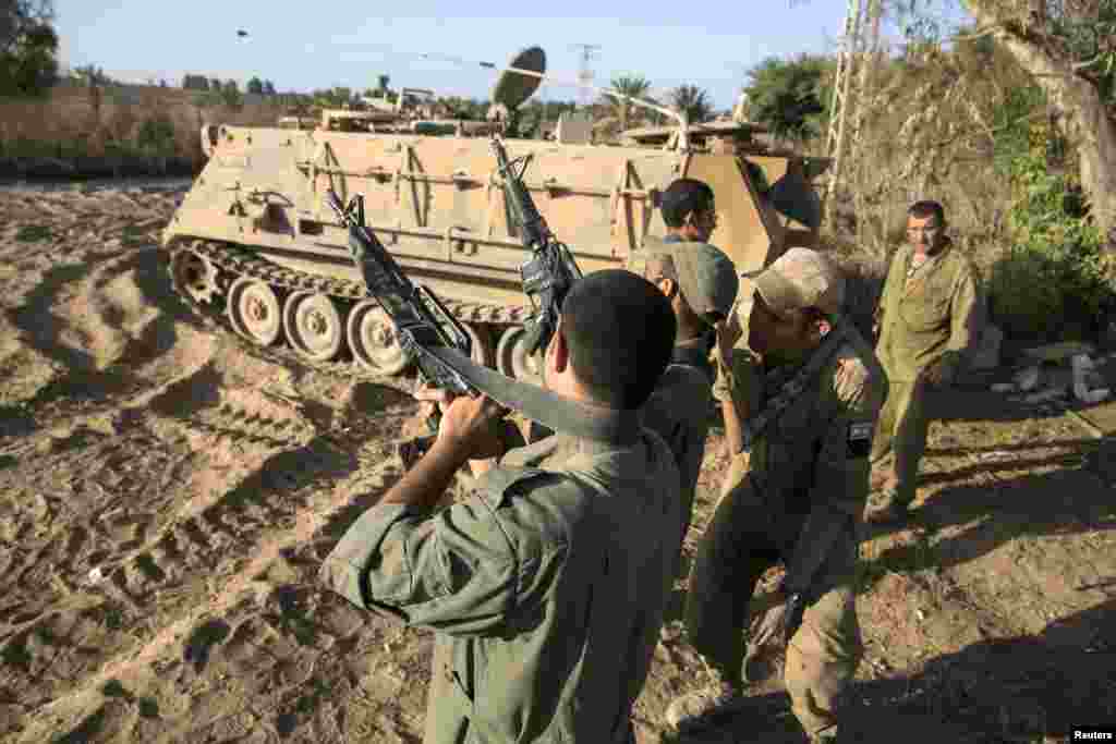 Israeli soldiers unload their weapons near the border with the Gaza Strip, Aug. 20, 2014.
