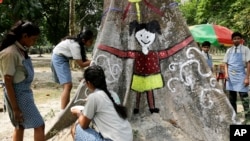 Indian schoolgirls paint a tree trunk at a park to mark Earth Day in Kolkata, April 22, 2017.