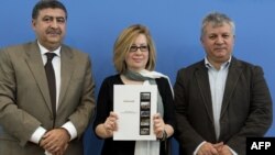 (From L) Members of the opposition Syrian National Council Murhaf Jouejati, Afra Jalabi, and member of the opposition National Change Currents Amr Al-Azm following a press conference in Berlin, August 28, 2012. 