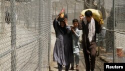 Warga Afghanistan melewati pagar keamanan untuk memasuki wilayah Pakistan (foto: dok). 
