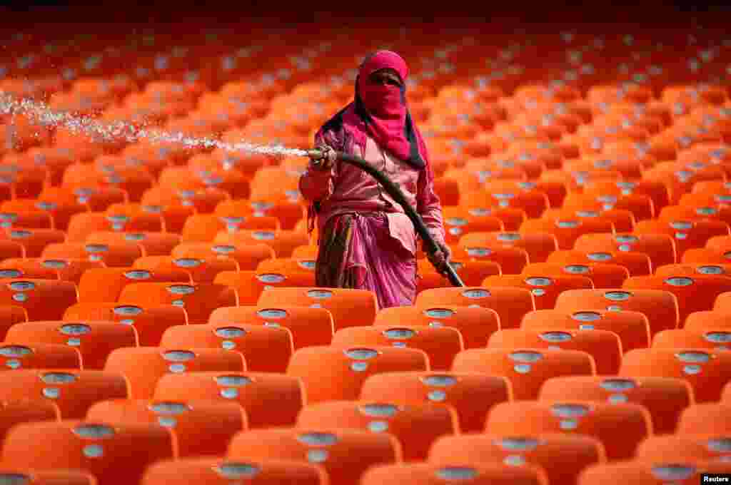 A worker cleans the seats at Sardar Patel Gujarat Stadium, where India and England are scheduled to play their third test match, in Ahmedabad, India.