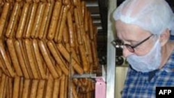 Seorang pemilik pabrik sosis memeriksa produk buatannya.