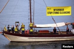 FILE - Protesters from Amnesty International display banners regarding the the Rohingya crisis in Myanmar as they sail near the venue for the one-off summit of 10-member Association of Southeast Asian Nations (ASEAN) being held in Sydney, Australia, March 16, 2018.
