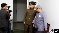 Ông Kenneth Bae được đưa đi sau khi nói chuyện với các phóng viên tại Bệnh viện Hữu nghị Bình Nhưỡng, 20/1/2014