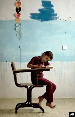 In this Aug. 22, 2018 photo, an orphaned Yazidi girl draws during arts and crafts time at an orphanage in Sheikhan, Iraq.