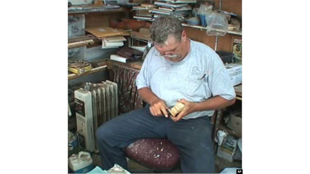 Bob Jobes hard carves a wooden decoy duck.
