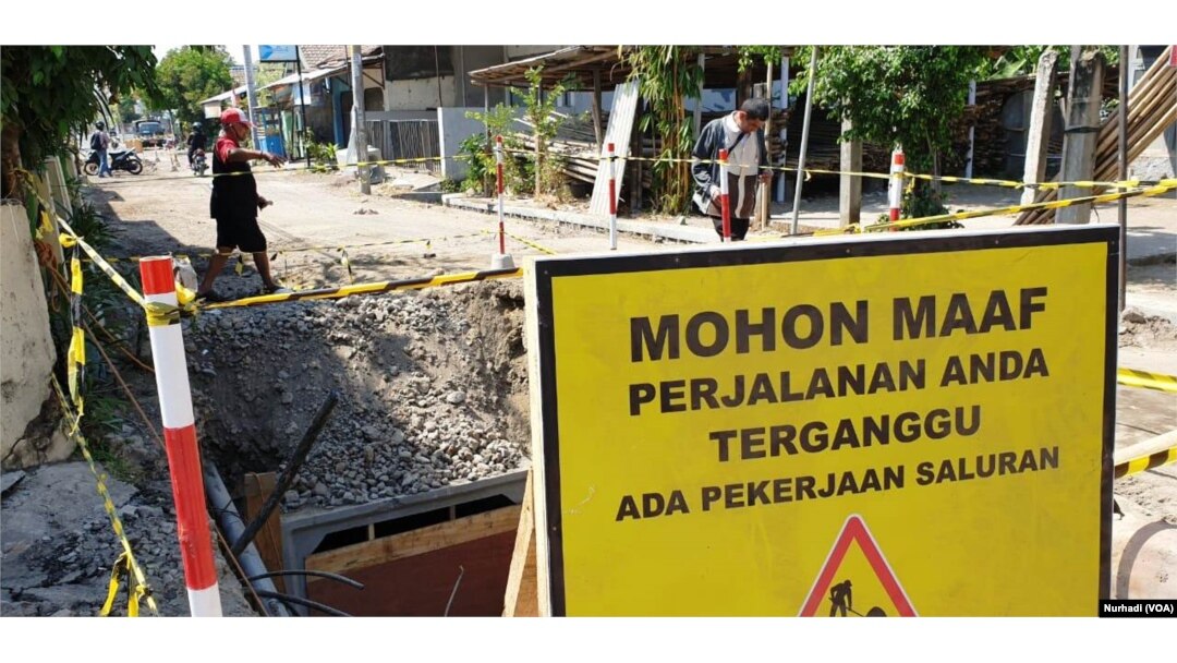 Warga melintas di lokasi proyek yang terhenti karena menjadi obyek OTT KPK. (Foto:VOA/Nurhadi)