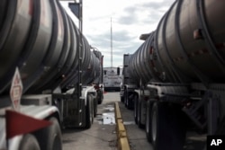 Tanker trucks wait parked inside the storage and dispatch terminal of Petroleos Mexicanos (Pemex), Mexico's state-owned oil company, in the port of Veracruz, Mexico, Dec. 30, 2016.