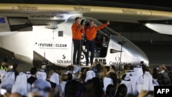 Bertrand Piccard (R) and Andre Borschberg (L), pilots of the solar powered Solar Impulse 2 aircraft, are greeted upon arrival at Al Batin Airport in Abu Dabi to complete its world tour flight, July 26, 2016, in the United Arab Emirates.