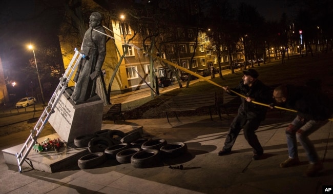 FILE - Activists in Poland pull down a statue of a prominent deceased priest, Father Henryk Jankowski, who allegedly abused minors sexually, in Gdansk, Poland, Feb. 21, 2019.