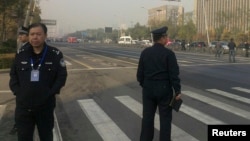 FILE - Police stand guard in front of the Shanxi Provincial Communist Party office building after explosions in Taiyuan, Shanxi Province, Nov. 6, 2013.