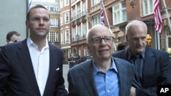 James and Rupert Murdoch (C) and a minder leave the Stafford Hotel in St James's Place, central London July 10, 2011