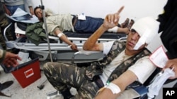 Wounded rebel fighters are treated in a hospital in Ajdabiyah after being brought in from the road to Ras Lanuf, in Libya, March 30, 2011