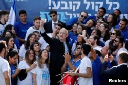 Benny Gantz, leader of Blue and White party, takes a selfie with supporters outside the party headquarters in Tel Aviv, Israel, April 8, 2019.