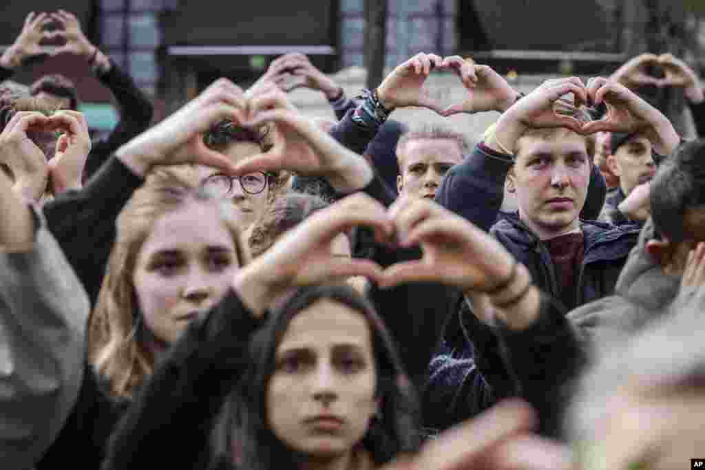 گردهمایی مردم با علامت قلبی شکل دستانشان در اولین سالگرد حملات تروریستی بروکسل.