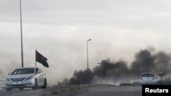 FILE - Smoke rises during heavy clashes between rival factions in Tripoli, Libya, May 27, 2017.
