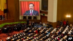 Perdana Menteri China Li Keqiang tampak dalam layar besar saat menyampaikan laporan kerja dalam pembukaan Kongres Rakyat Nasional di Beijing (5/3). (AP/Ng Han Guan)