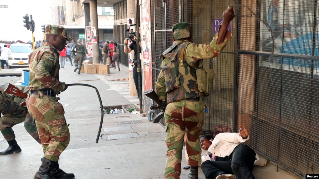 FILE: Soldiers beat a supporter of the opposition Movement for Democratic Change party of Nelson Chamisa outside the party's headquarters as they await the results of the general elections in Harare, Zimbabwe, Aug. 1, 2018.