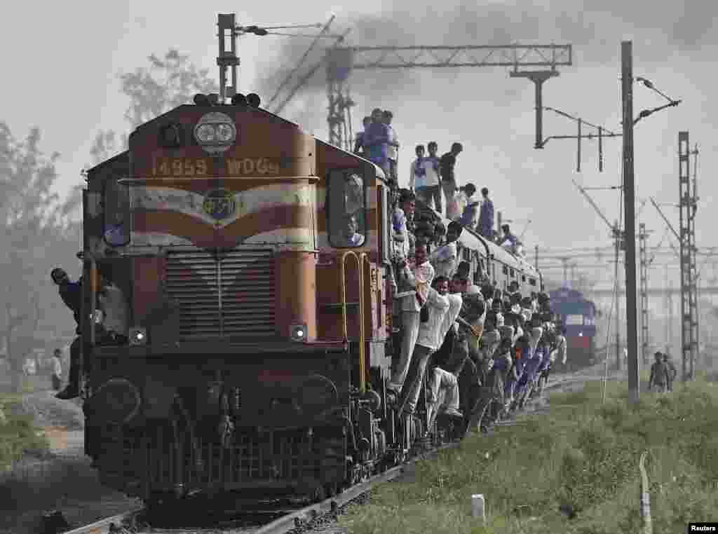 Para penumpang India menaiki kereta yang penuh sesak di kota Loni, Uttar Pradesh.