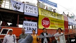 Cambodian non-governmental organization (NGOs) activists hold a cut-out of Mekong dolphin, left, and cut-out of other species during a protest against a proposed Don Sahong dam, in Phnom Penh, Cambodia, Thursday, Sept. 11, 2014.