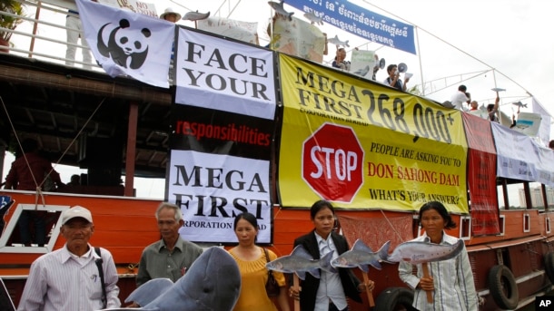 Cambodian non-governmental organization (NGOs) activists hold a cut-out of Mekong dolphin, left, and cut-out of other species during a protest against a proposed Don Sahong dam, in Phnom Penh, Cambodia, Thursday, Sept. 11, 2014.