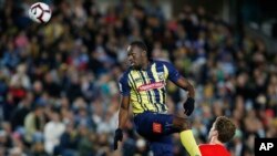 FILE - Usain Bolt goes up for a header during a friendly trial match between the Central Coast Mariners and the Central Coast Select in Gosford, Australia, Aug. 31, 2018.