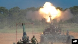 FILE - Members of Taiwan's military fire artillery from self-propelled Howitzers during the annual Han Kuang exercises in Hsinchu, northeastern Taiwan, Sept. 10, 2015. 