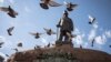 Pigeons fly over a statue of the late Paul Kruger in Church Square, Pretoria, South Africa, Dec. 13, 2018. 