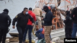 Paramédicos revisan el cuerpo de un niño migrante hondureño, que se ahogó mientras cruzaba las gélidas aguas del río Grande desde México hacia EE.UU. con su madre y su hermana, según medios locales, en Piedras Negras, México, el 17 de febrero de 2021.