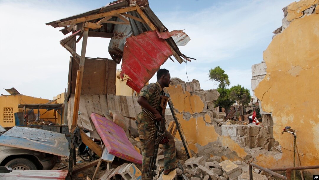 Tentara Somalia berdiri dekat gedung yang hancur di dekat kantor polisi di Mogadishu, Somalia (9/5). (AP/Farah Abdi Warsameh)