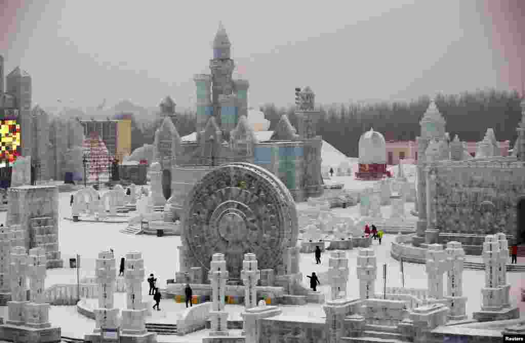 Visitors look around ice sculptures ahead of the 31st Harbin International Ice and Snow Festival in the northern city of Harbin, Heilongjiang province, China. The winter festival will be officially opened on Jan. 5, 2015.