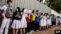 School students hold signs during a pro-democracy protests near their school in Hong Kong on June 12, 2020. (Photo by ISAAC LAWRENCE / AFP)