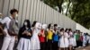 FILE - School students hold signs during a pro-democracy protests near their school in Hong Kong on June 12, 2020.