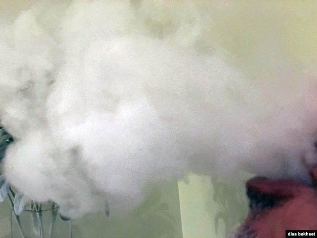 FILE- A man vapes with an electronic cigarette, exhales in Fair Oaks, Virginia. (Photo: Diaa Bekheet).