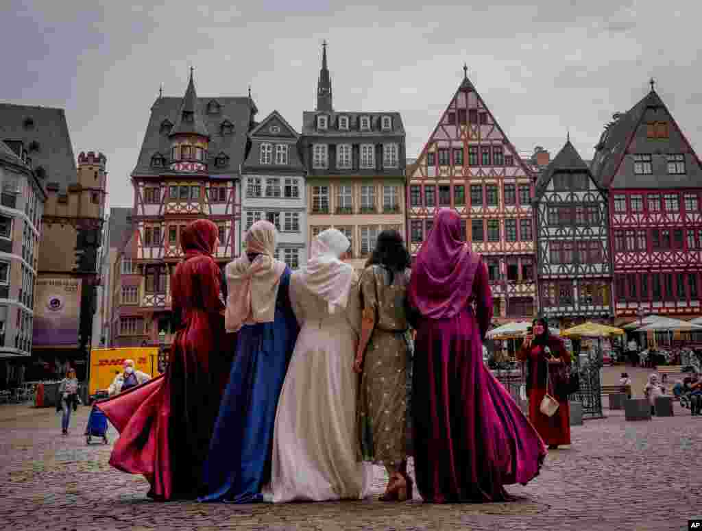 عکس یادگاری گرفتن یک عروس (وسط) و همراهانش بعد از اجرای عقد در تالار شهر در میدان رومربرگ در فرانکفورت، آلمان 